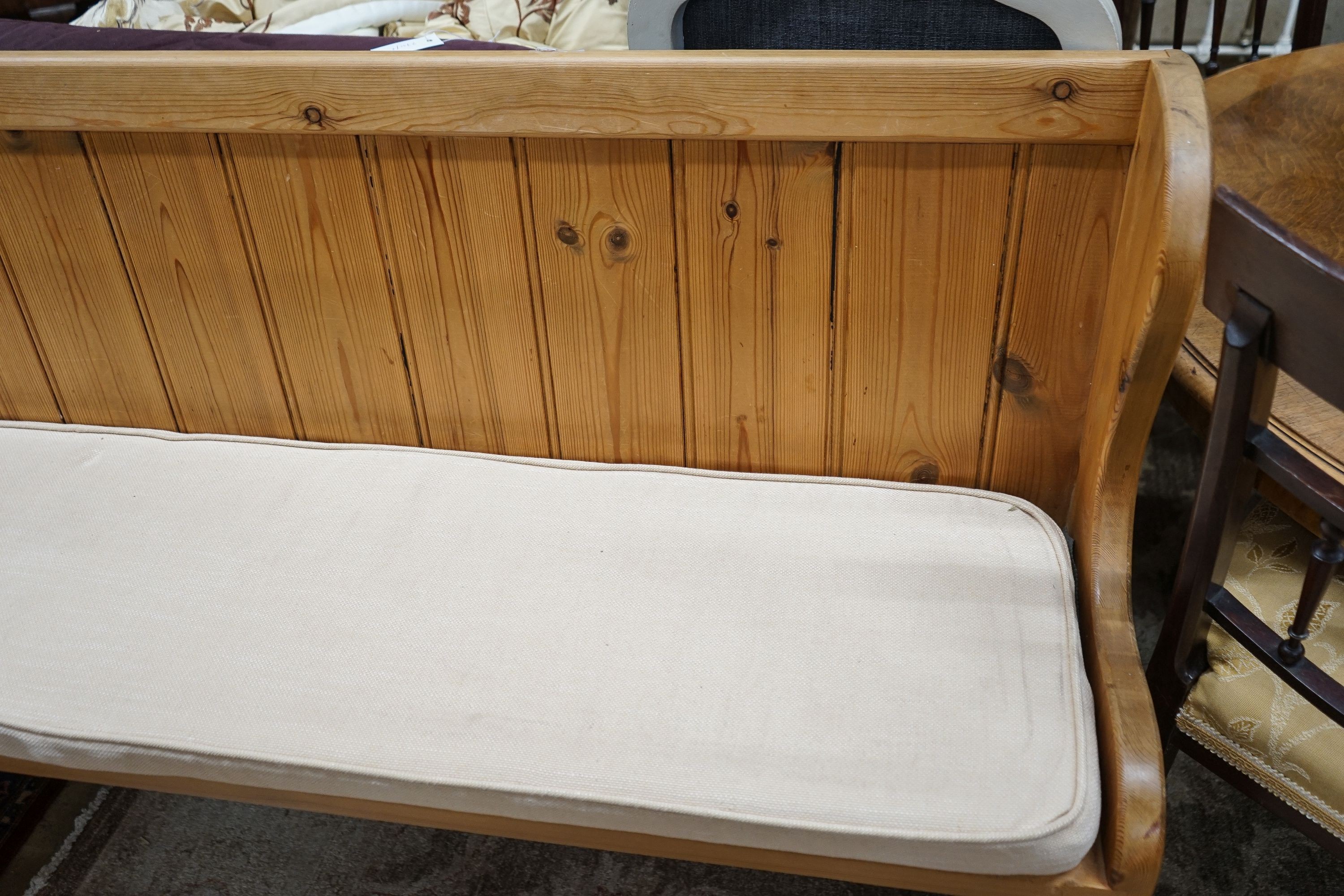 A Victorian style pitch pine pew with cushion seat, length 187cm, depth 40cm, height 88cm